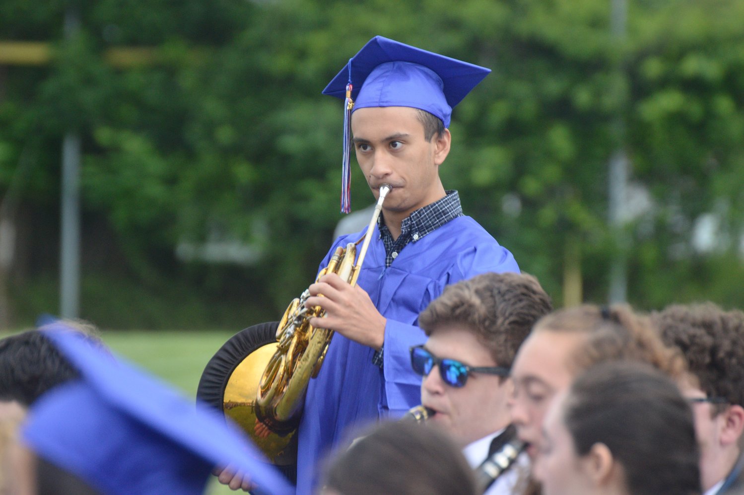French horn player Tito Villacorta performs one final song with the Portsmouth High School band before receiving his diploma.