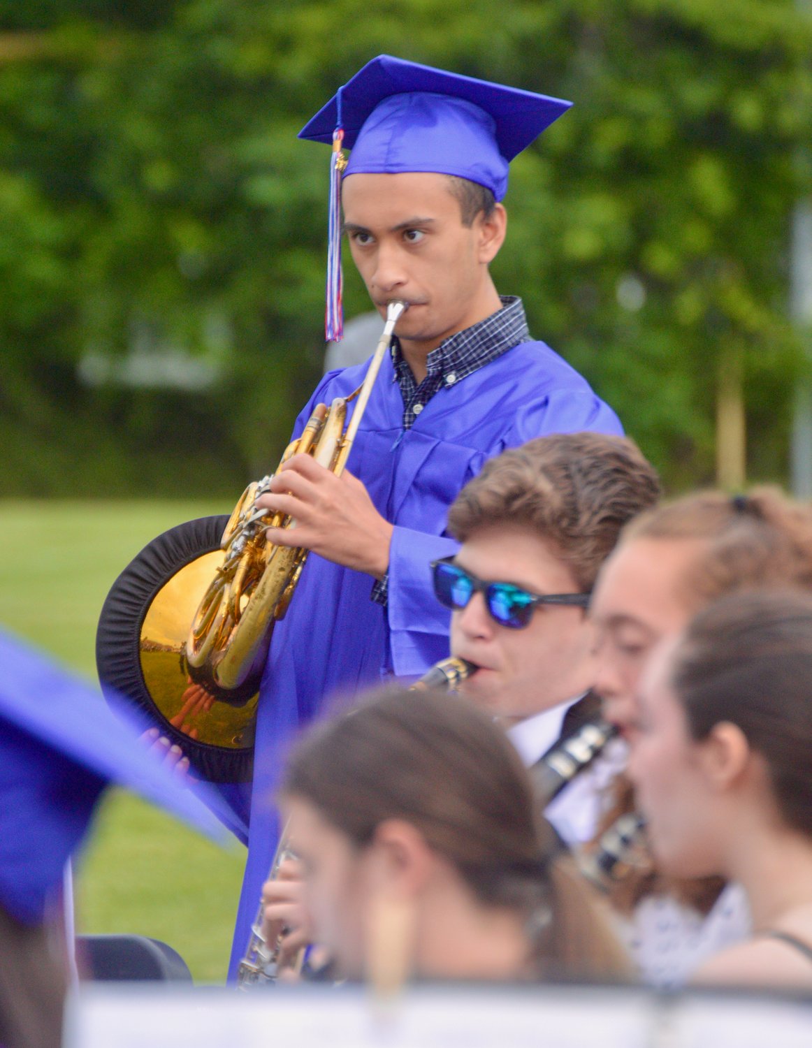 French horn player Tito Villacorta performs one final song with the Portsmouth High School band before receiving his diploma.