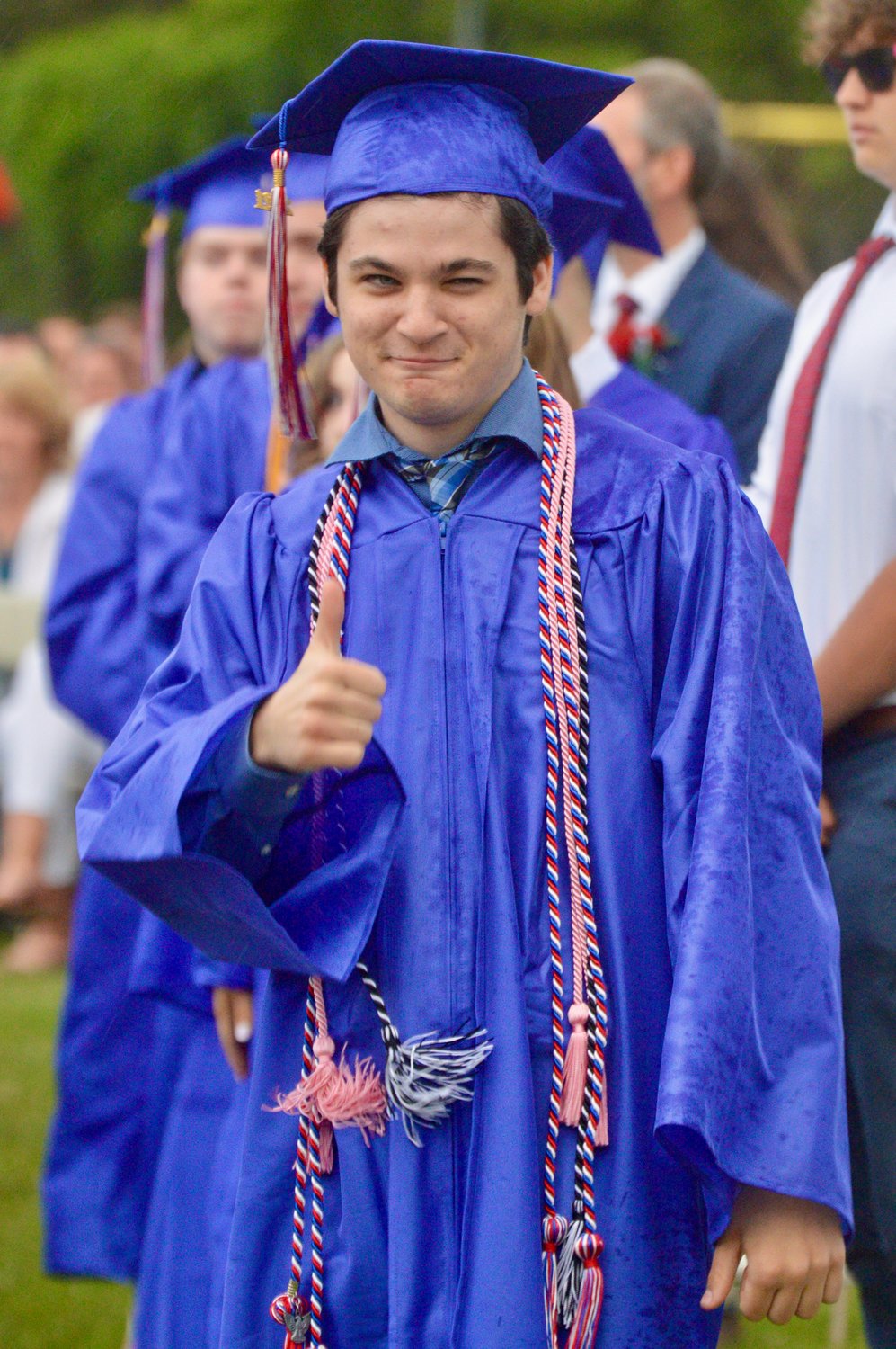Zachary Rousseau flashes a wink and a thumbs-up before taking the stage to receive his diploma.
