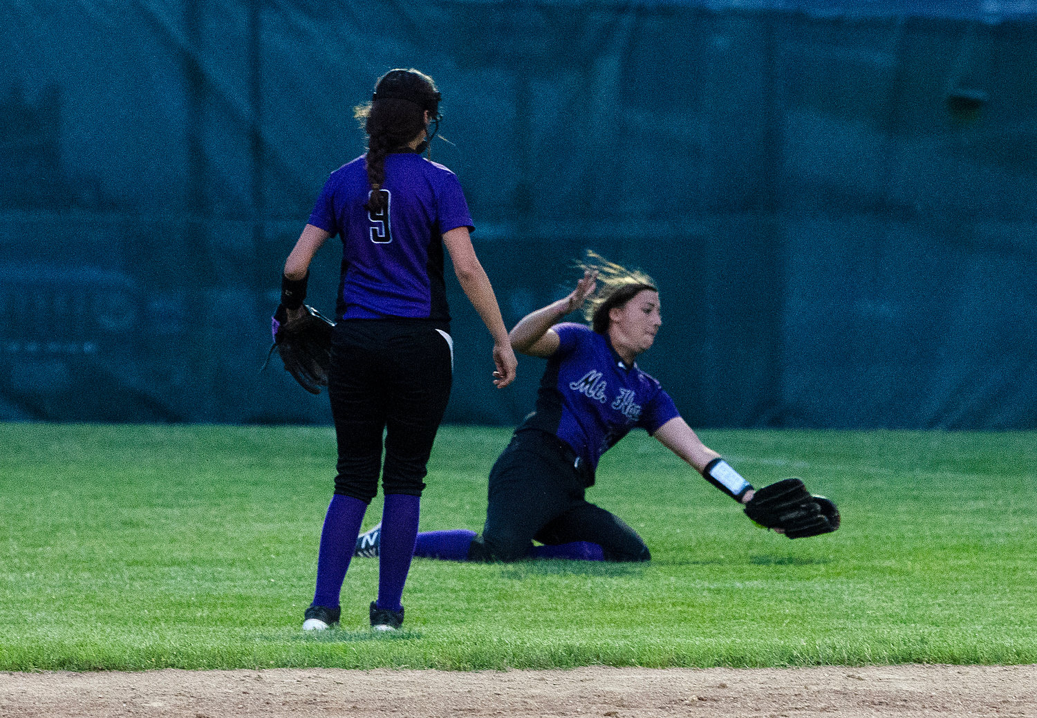 Huskies right fielder Logan Leveque slides to make a catch, but the ball grazed her glove and bounced into the outfield.