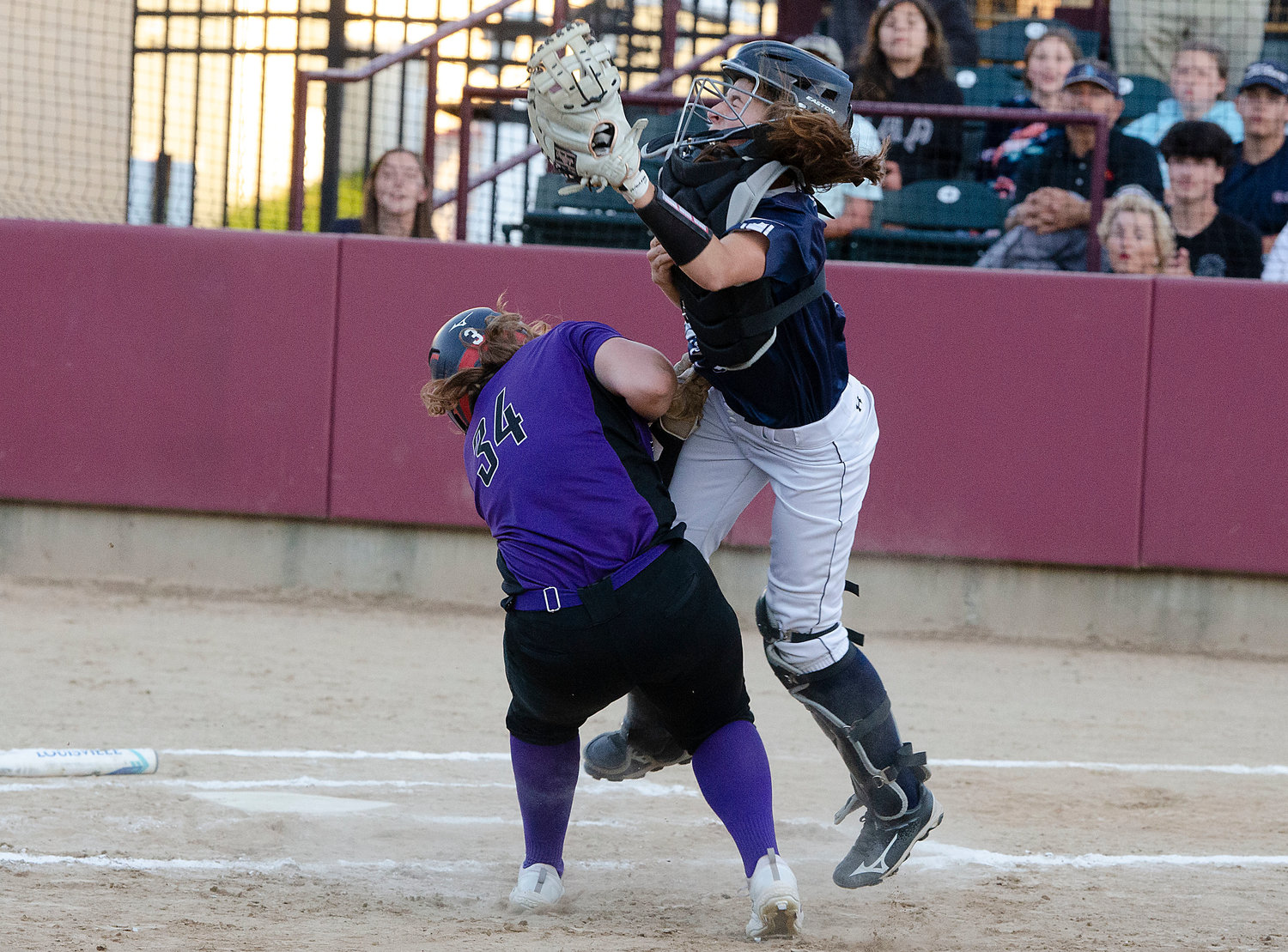 Grace Stephenson slams into the Broncos catcher Kaitlin Pristawa on her way to scoring the Huskies second run in the first inning.