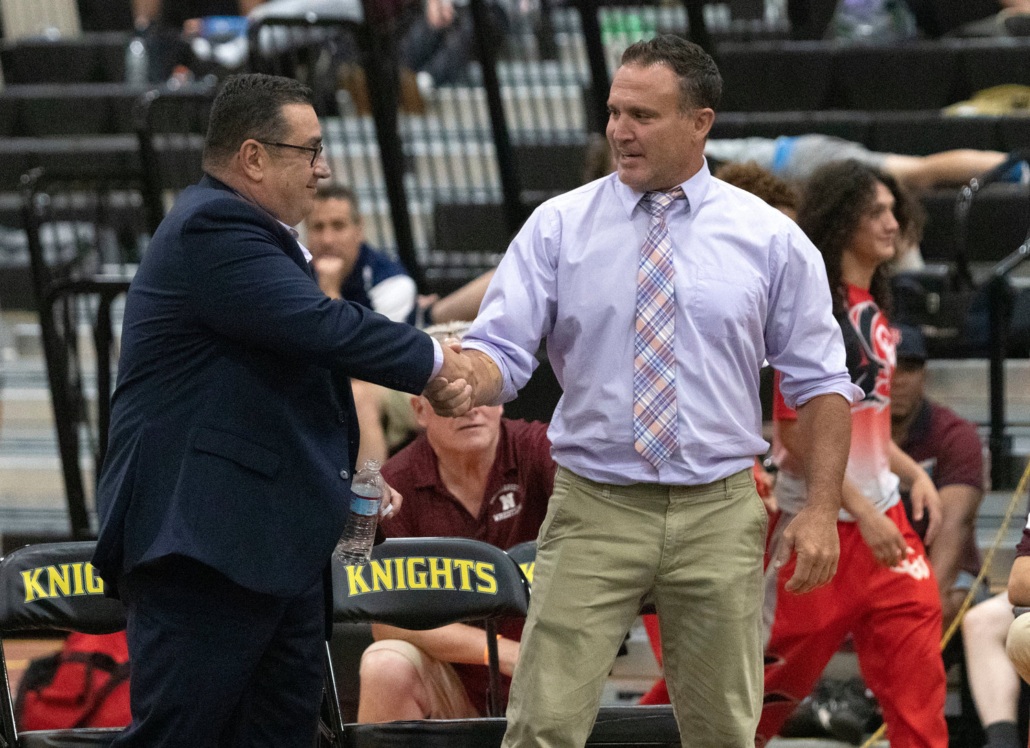 Coaches Mike Perreira (left)  and Eric Francis shake hands after Cory Grifka won the 182 pound title and clinched the team state championship.