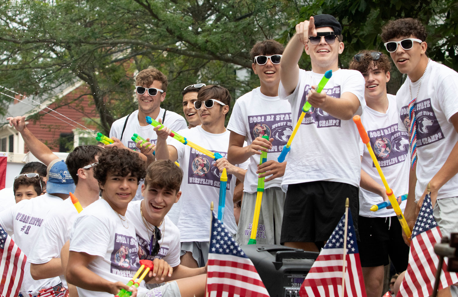 The state champion Mt. Hope High School wrestling team has fun while spraying water guns atop their float.