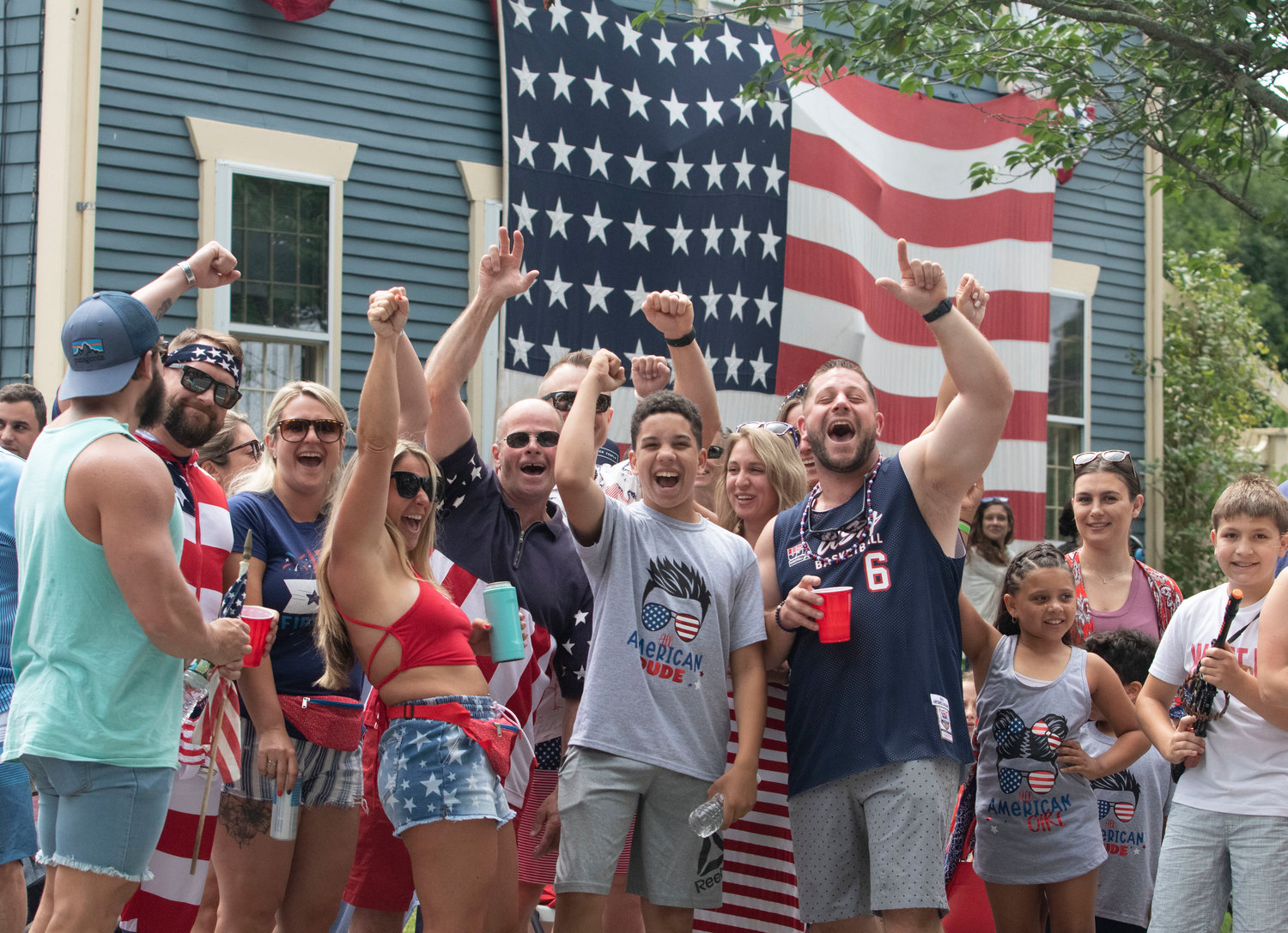 Daniel Coffland (right) and friends cheer during the parade, in front of his house on Hope Street.