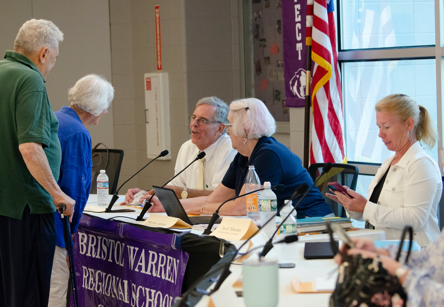 Residents speak to school committee members Victor Cabral (mid-left) and Marjorie McBride before the meeting on Monday night at Mt. Hope High School.  School committee member Tara Thibaudeau is right.