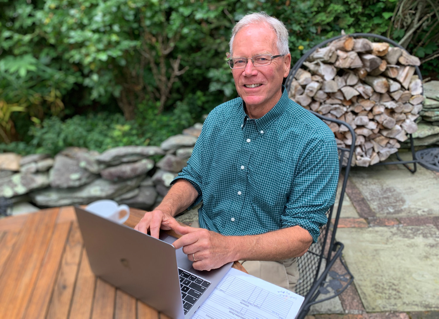 Bruce Burdett at a patio table outside his Bristol home, where he often works. The editor of The Sakonnet Times and Westport Shorelines is retiring this week after 45 years with East Bay Newspapers. “There’s something in all of us that likes to tell people stories, and this was my way to be able to do it,” he said.