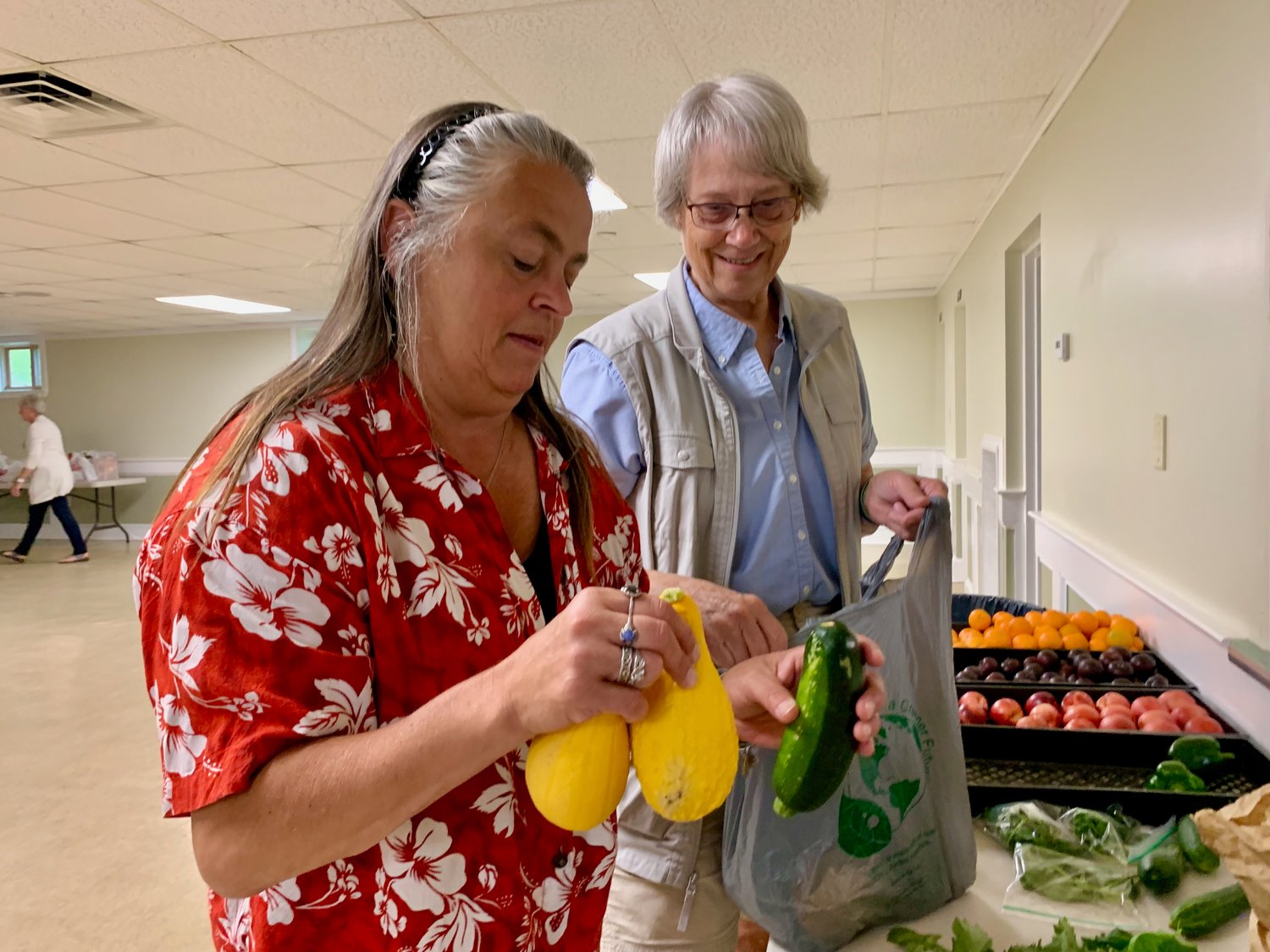 Mary Anne Crittenden (left), director of the St. John Lodge Food Pantry on Sprague Street, along with volunteer Peggy Matteson, bag fresh produce donated by a local resident Wednesday morning. They remind farmers and other residents that the pantry gladly accepts any surplus fresh produce. The food bank feeds about 45 to 50 families every week.