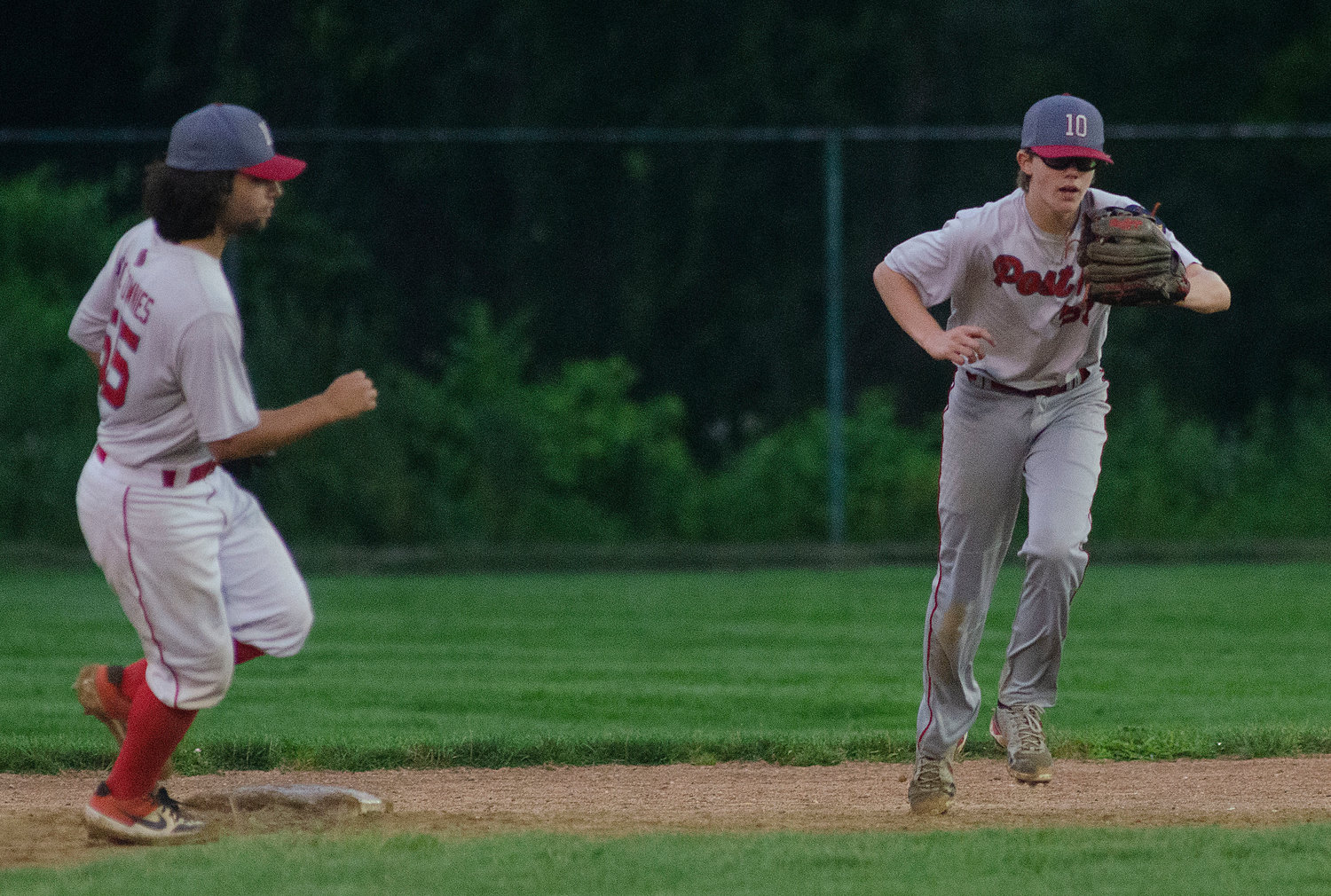 Riverside shortstop Oliver Andrews looks on as second baseman Brian Rutowski (right) snares a line drive to secure a victory over Scituate Thursday night, July 29.
