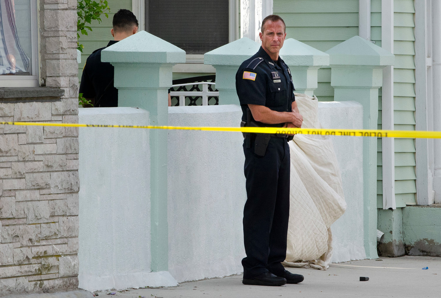 Warren police guard a shrouded body, of a suspected shooter confirmed to have been killed after exchanging fire with polce on Water Street in Warren.