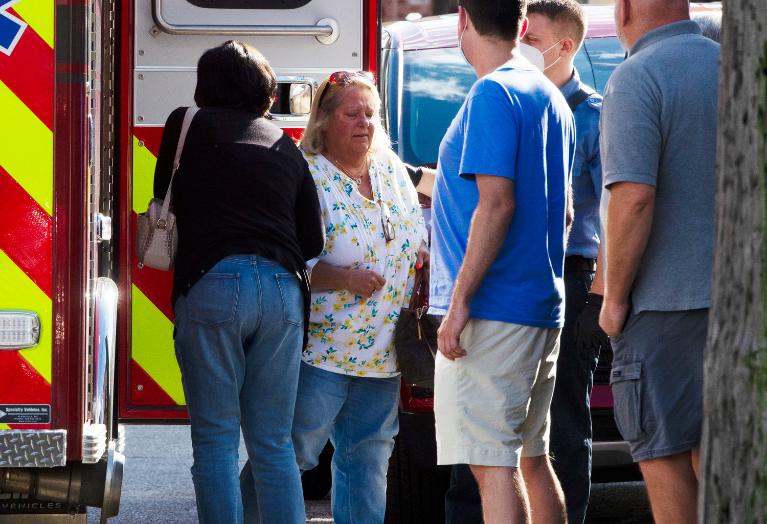 A family member of a shooting victim is comforted outside a rescue truck at the Italian American Club in Warren on Thursday.
