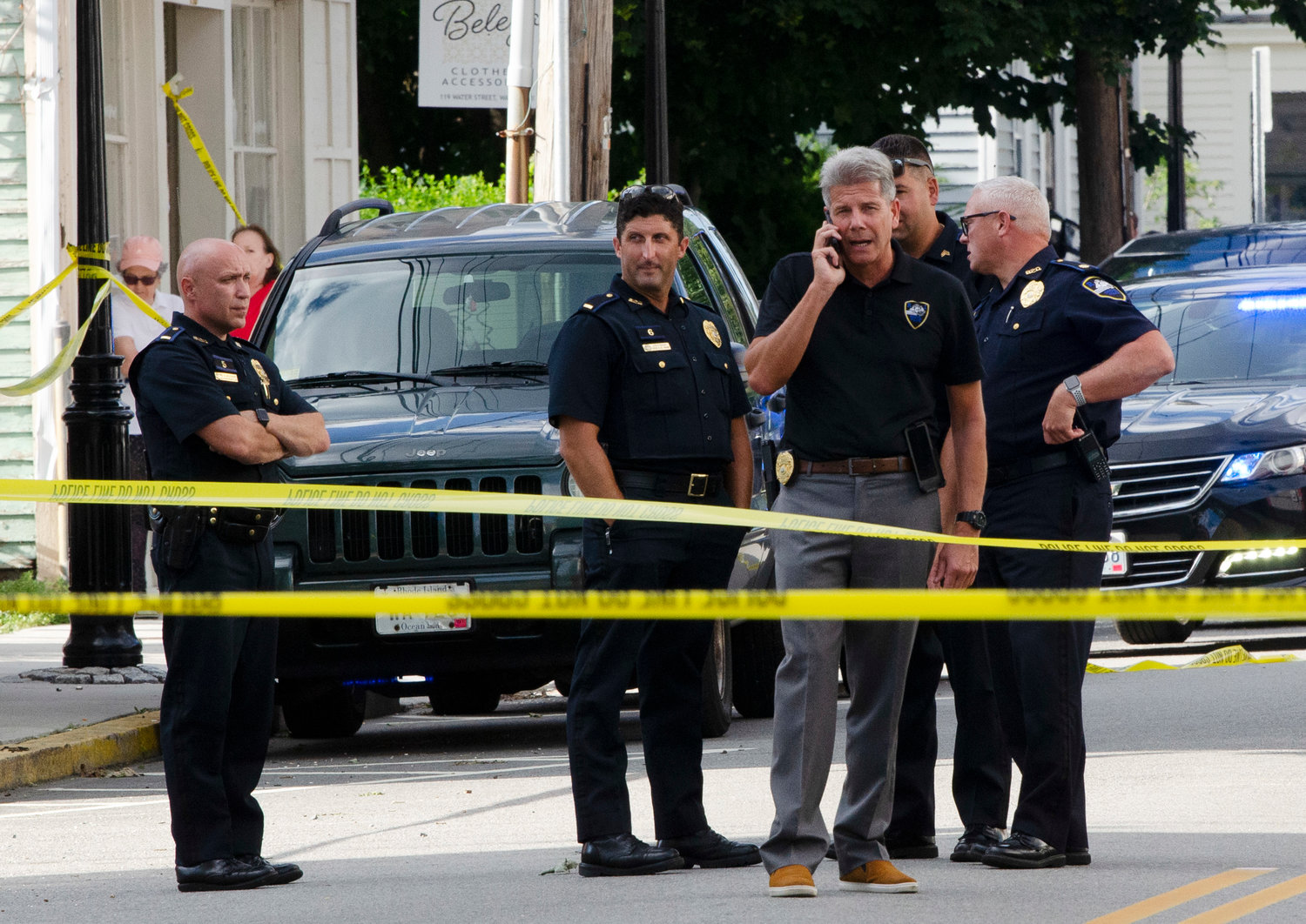 Bristol Police Lt. Steve St. Pierre (mid-left) looks on as Bristol Police Chief Kevin Lynch (right) speaks on the phone during the investigation on Water Street.