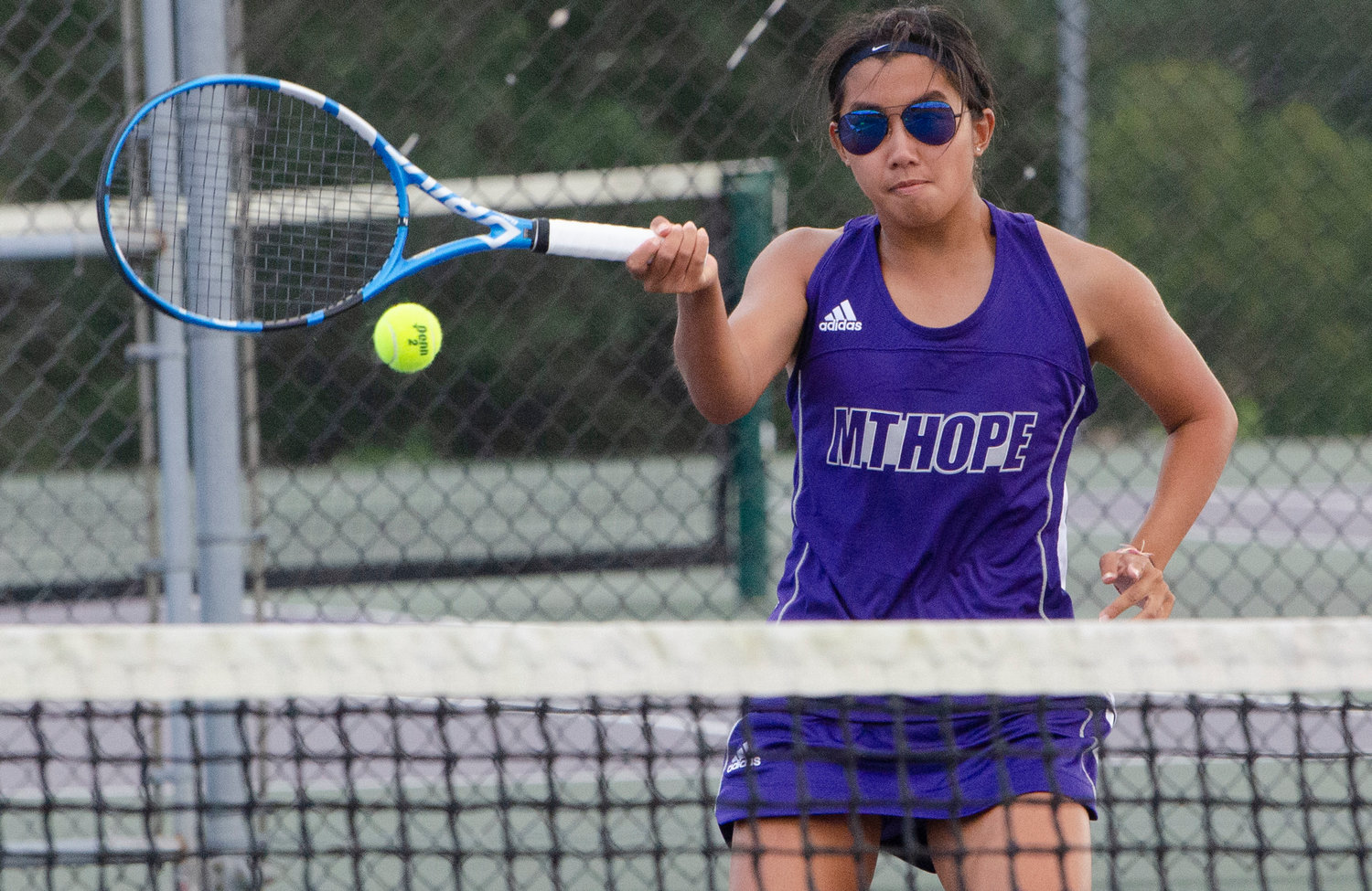 Second singles player Eva White slams a shot at the net, past her South Kingstown opponent.