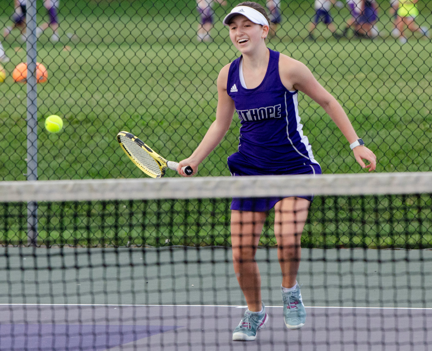 Three singles player Cate Merriam runs in to defend a drop shot.