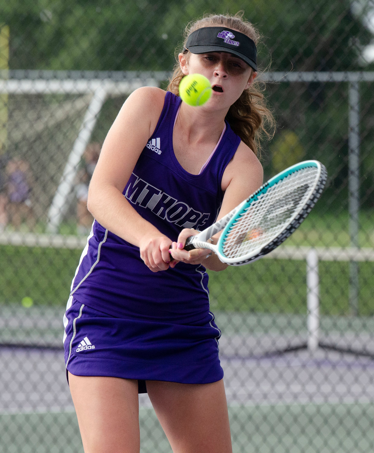 four singles player Ella Quesnelle hits a backhand during her match.