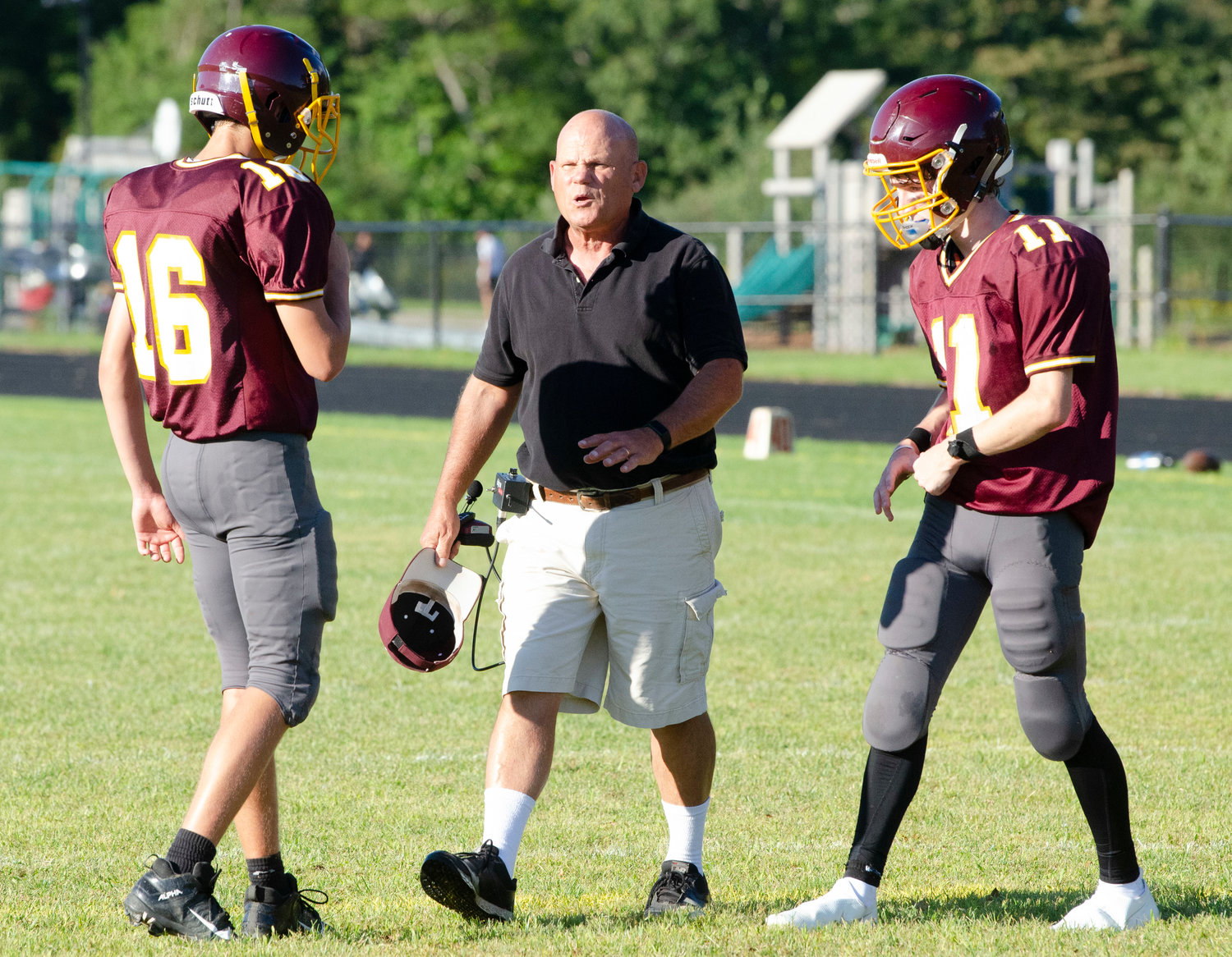 Tigers head coach Bob Murray speaks to quarterback Ben Sowa (left) and wide receiver Reilly Nicholas during a time out in the second quarter.
