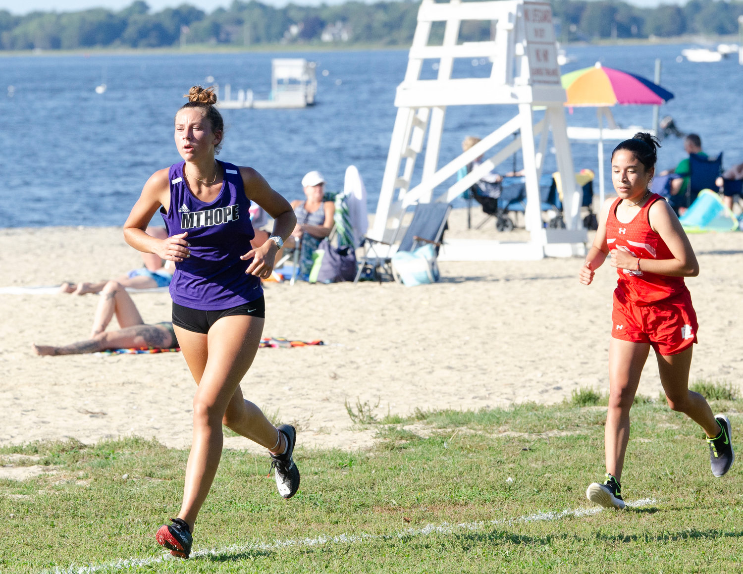 Reyn Ferris (left) runs by the beach to the finish line. She placed seventh.