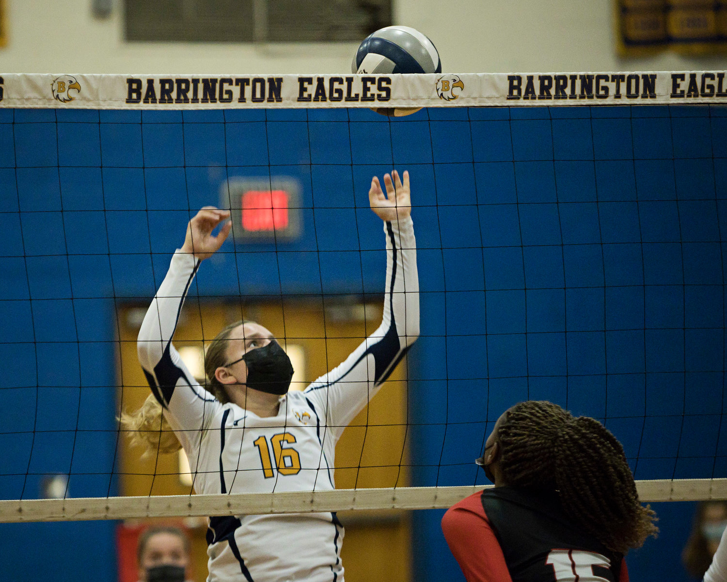 Michaela Baer attempts to block the ball from coming back over the 
net.