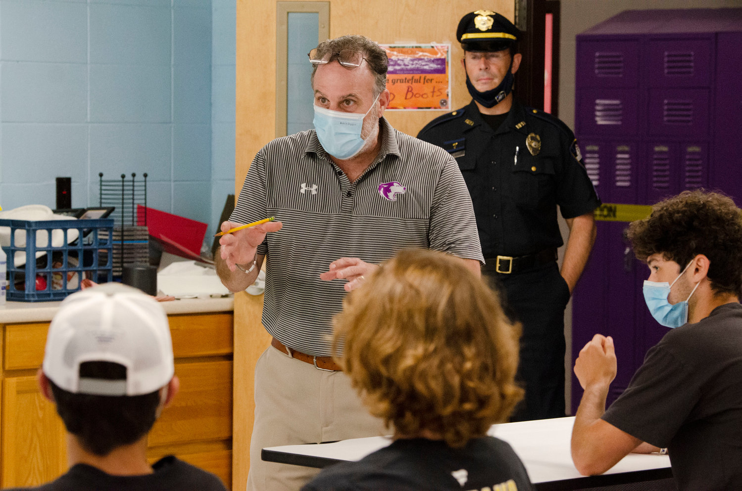 Mt. Hope High School teacher Brian Latessa talks to students in his Media Communications class last spring. Working with Bristol Police Department Sgt. Ricardo Mourato (rear), the students produced a recruitment video for the department.