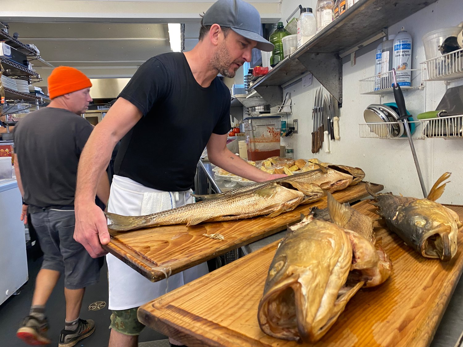 The Back Eddy's Nigel Vincent preps a pan of striped bass fresh out of the smoker.