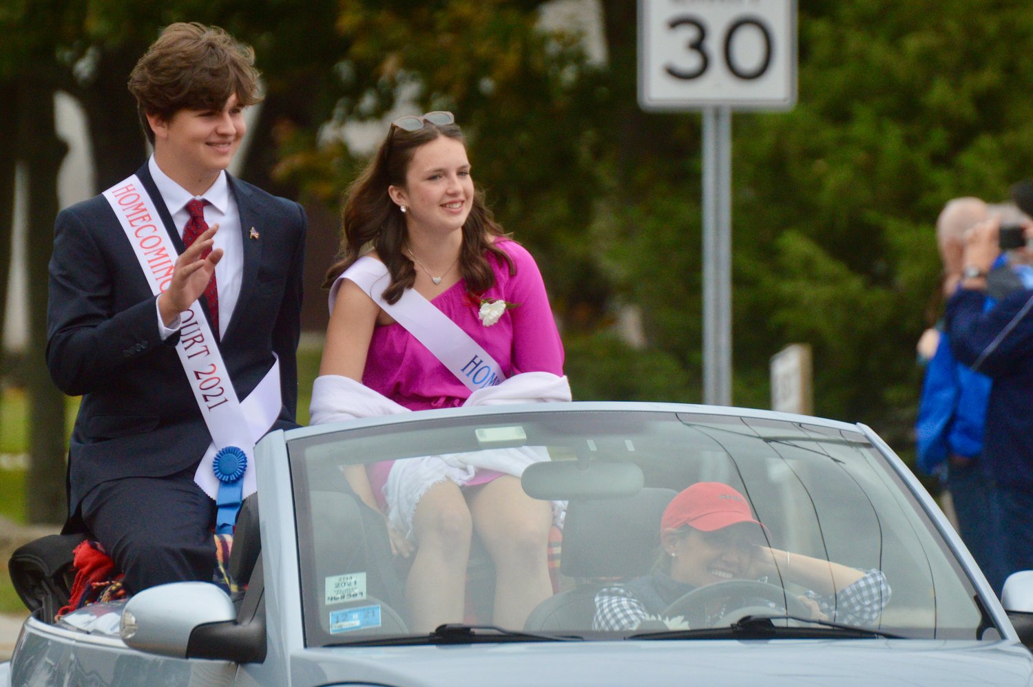 Andrew Lopes and Amory Kirwin of the Homecoming court greet spectators along East Main Road during the parade.