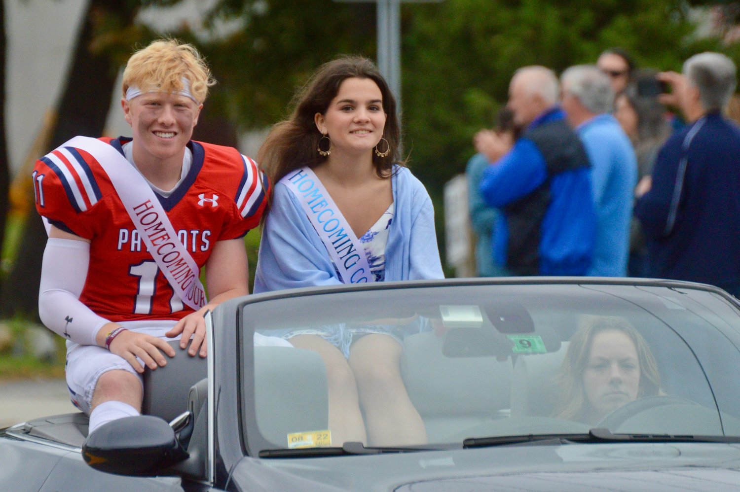 Gavin Bicho and Ruth McKinnon of the Homecoming court greet spectators along East Main Road during the parade.