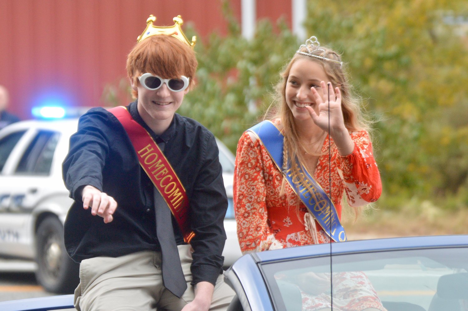 Joe Cawley and Grace Van Patten, Homecoming king and queen, greet spectators during the Homecoming parade before the game.