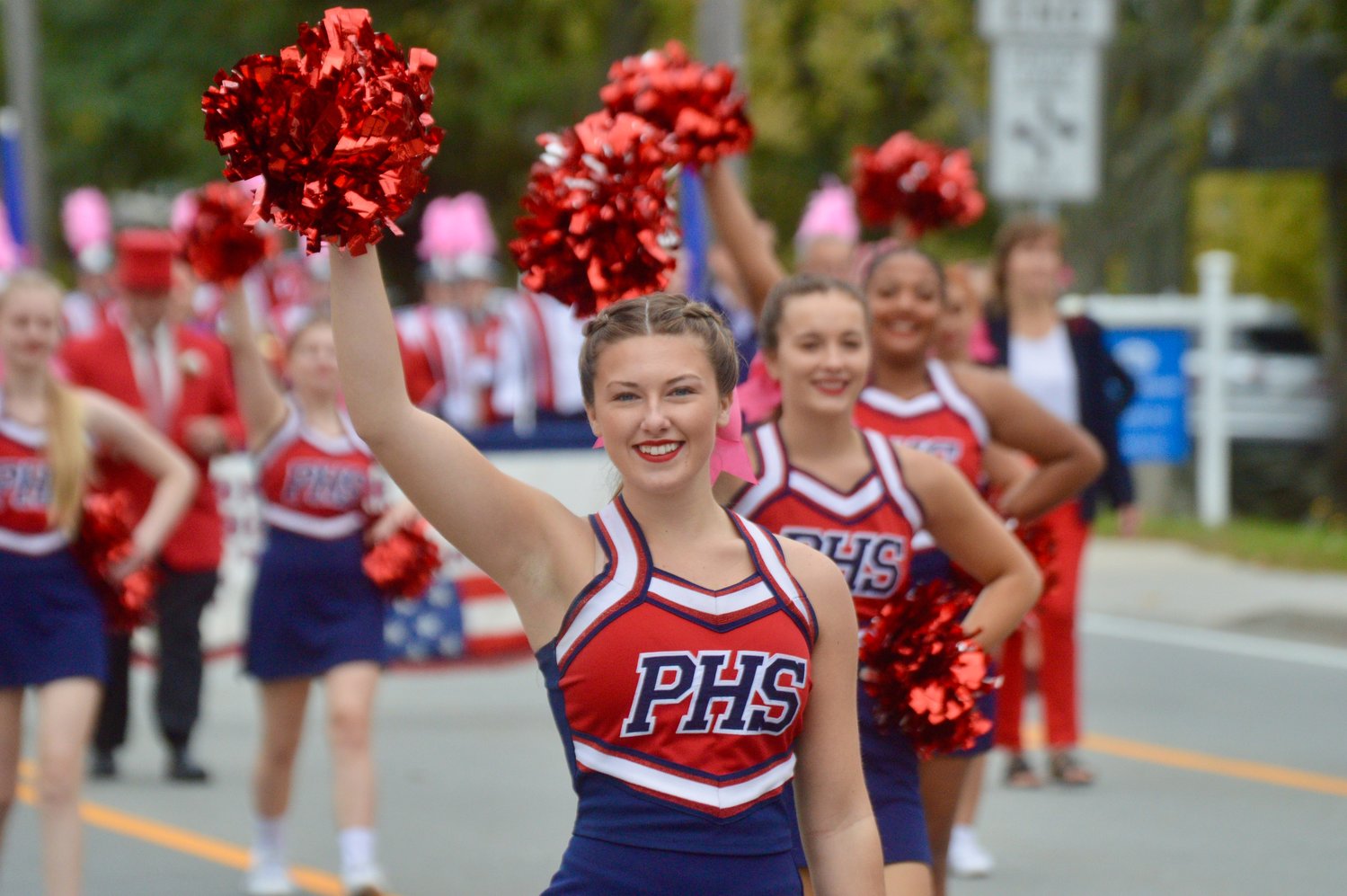 Cheerleader Phoebe Tavares, a junior, marches on East Main Road along with the rest of her squad in the Homecoming parade on Saturday.