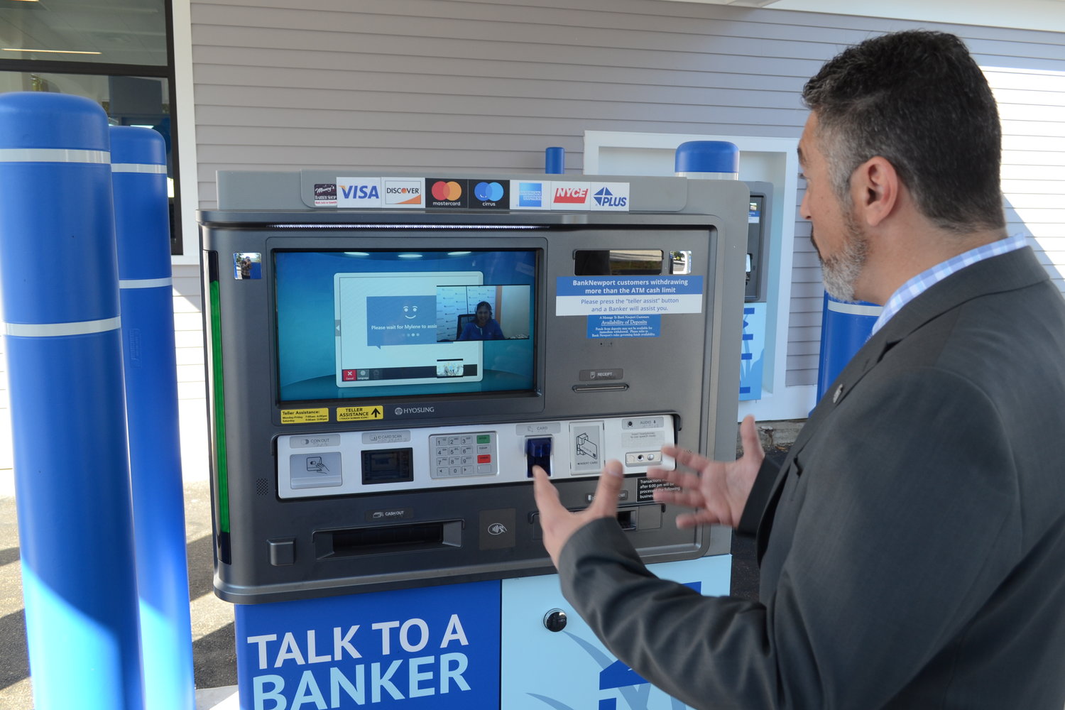Victor Correia, Vice President and branch sales manager of BankNewport’s Warren location, speaks with Myleen from the bank’s Middletown call center via one of the bank’s new PTMs (personal teller machines), which performs many functions above and beyond a traditional drive-up ATM.