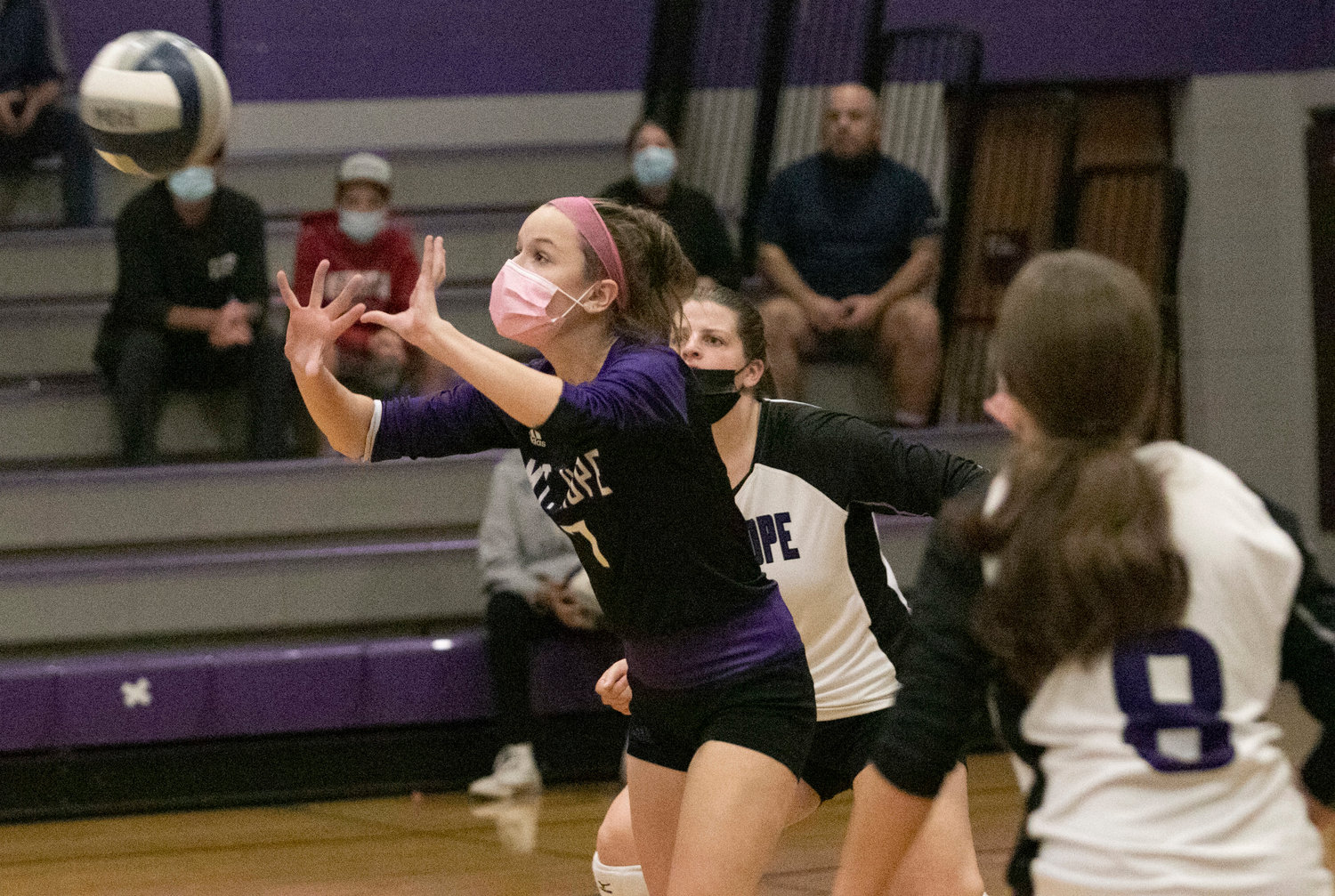 Grace Stephenson and Emma Torres look on as Erika Tally (middle) hits the ball over the net.