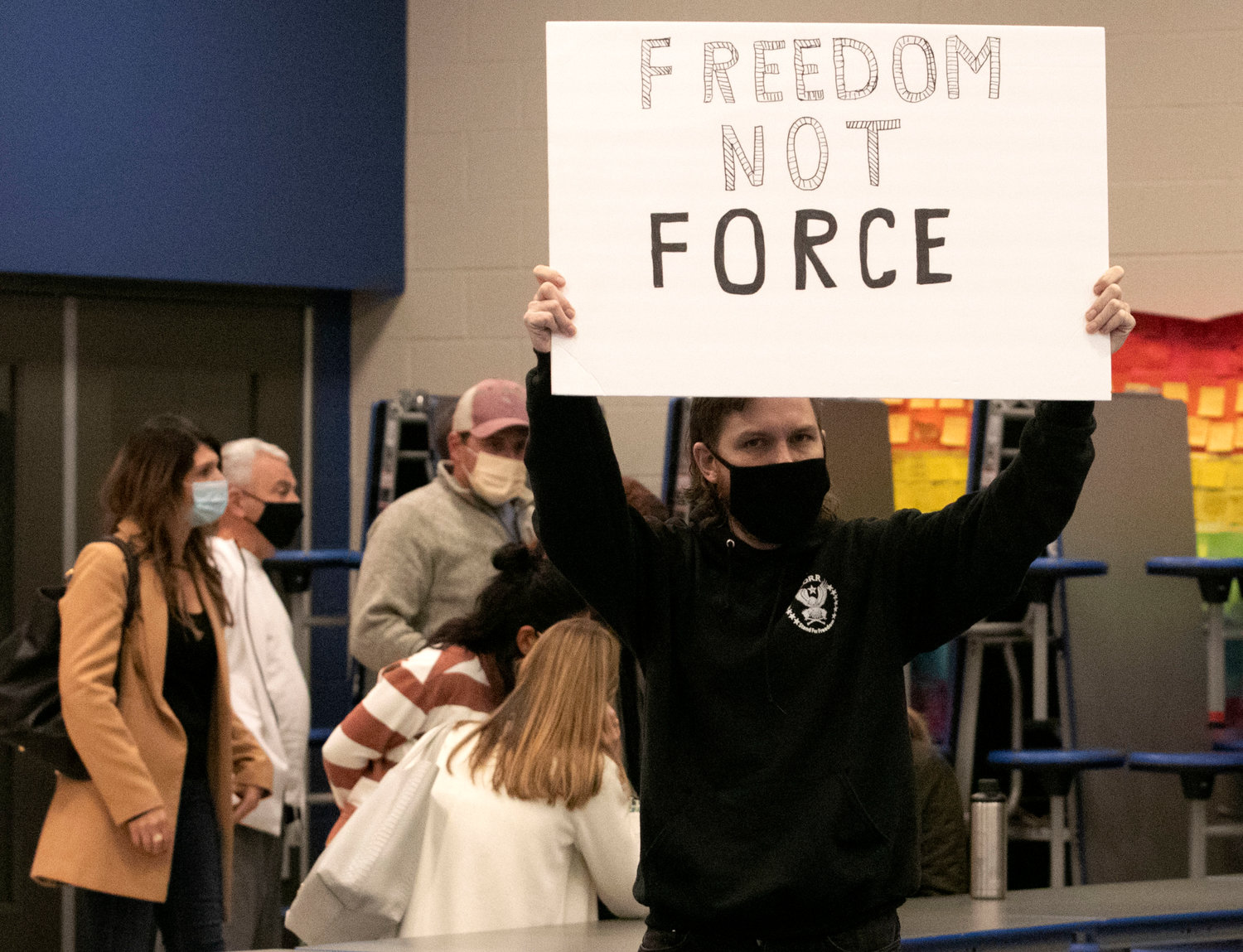 An audience member shouts "Freedom Not Force" following Thursday night's pre-termination hearing. The committee voted 3-1 to fire three unvaccinated teachers.