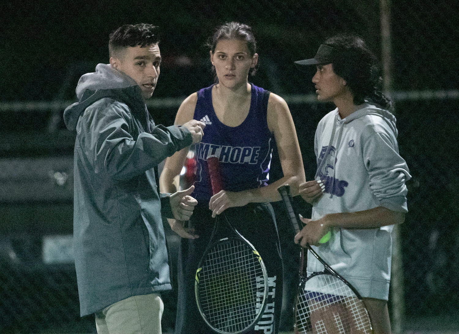 Assistant coach Tim Thorpe speaks to Emily Marino and Aditi Mehta between sets.