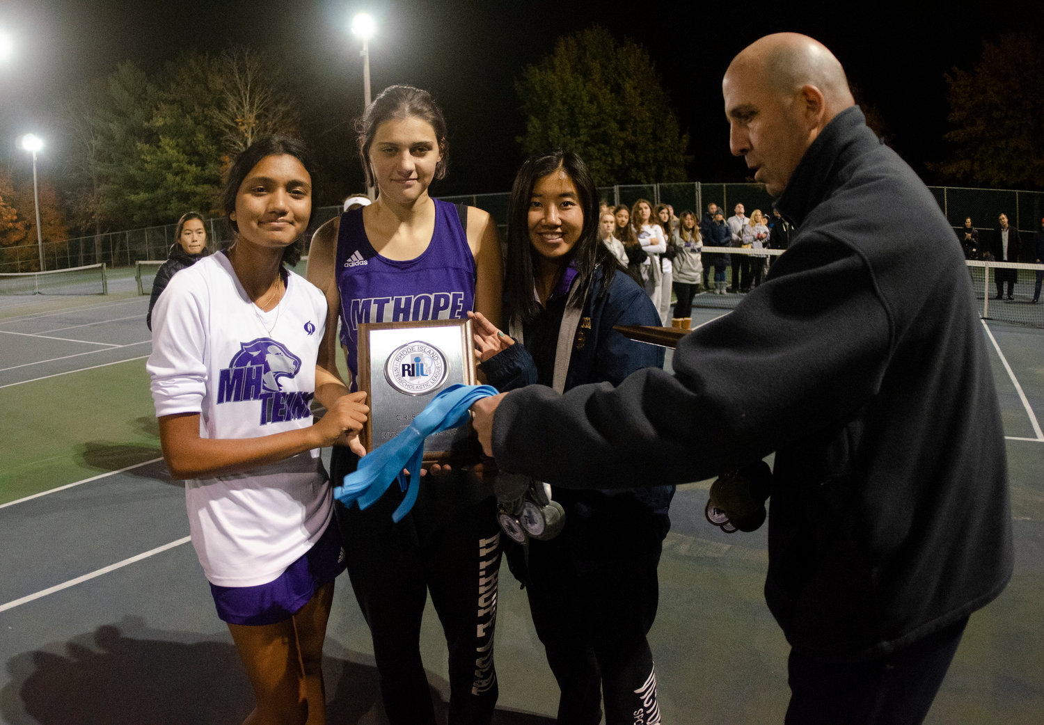 Senior captains Aditi Mehta (left), Emily Marino and Eva White accept the second place plaque from RIIL executive director Michael Lunney.