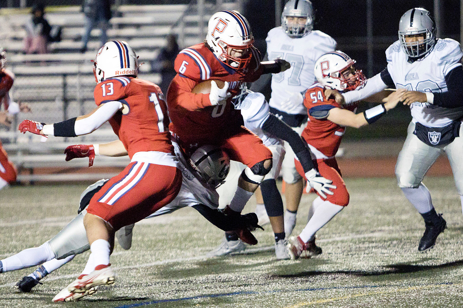 Marcus Evans leaps through the Shea defense to gain yardage for the Patriots during Friday's opening-round D-I playoff game won easily by Portsmouth, 48-14.