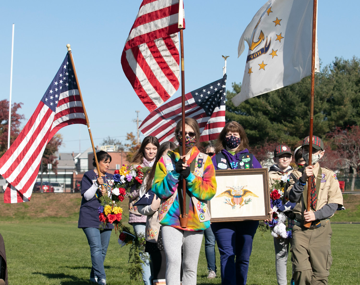 Katie Patalano (center) leads a group of city girls and boy scouts parading the colors during East Providence Veterans Memorial Expressway rededication ceremony held Saturday, Nov. 6, at Pierce Memorial Stadium.