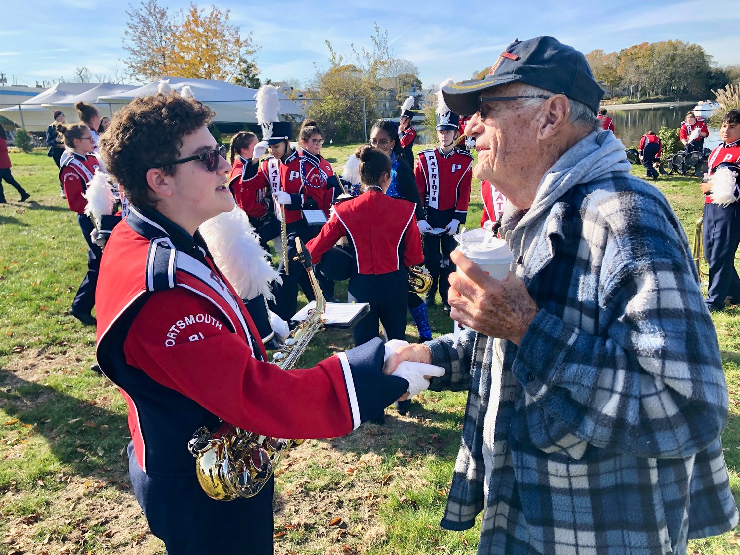 AJ Amaio (left) a senior member of the Portsmouth High School Marching Band, personally thanks Army veteran George Cushman, 90, for his service during a Veterans Day tribute at Thriving Tree Coffee House on Thursday, Nov. 11. Cushman, who regrets having stopped playing piano when he joined the military many years ago, urged band members to always keep playing music throughout their lives.
