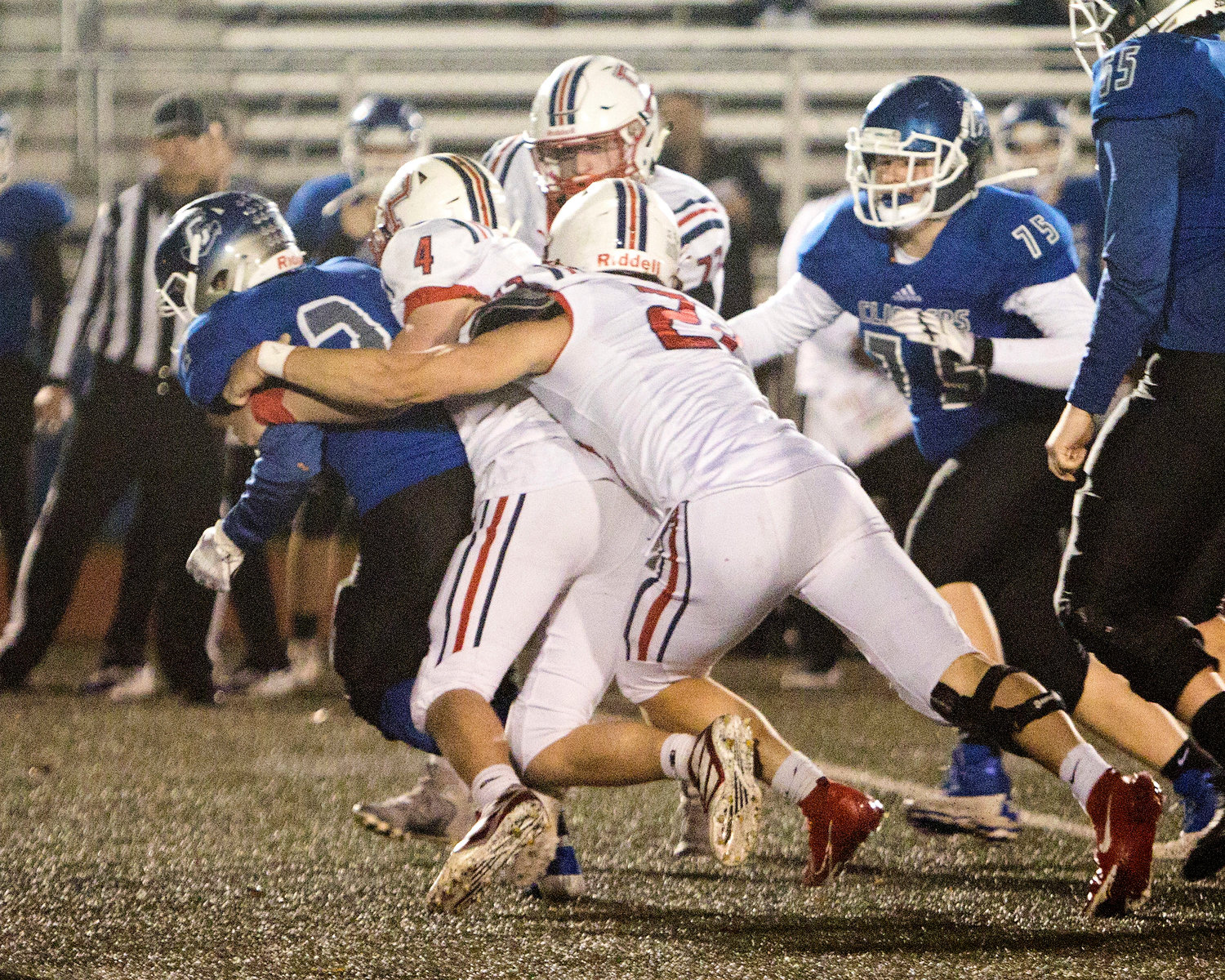 Luke Brennan (middle) and Thomas McGraw tackle a Cumberland opponent.