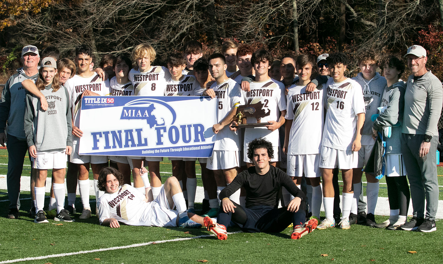 The team poses with the final four banner and trophy.