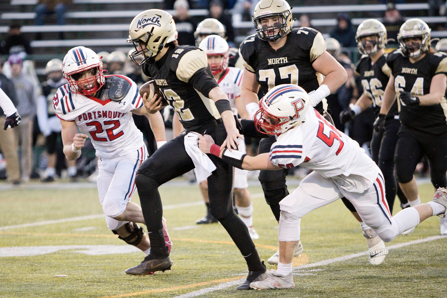 Thomas McGraw (left) and Henry Rodrigues tackle a North Kingstown ball-carrier.