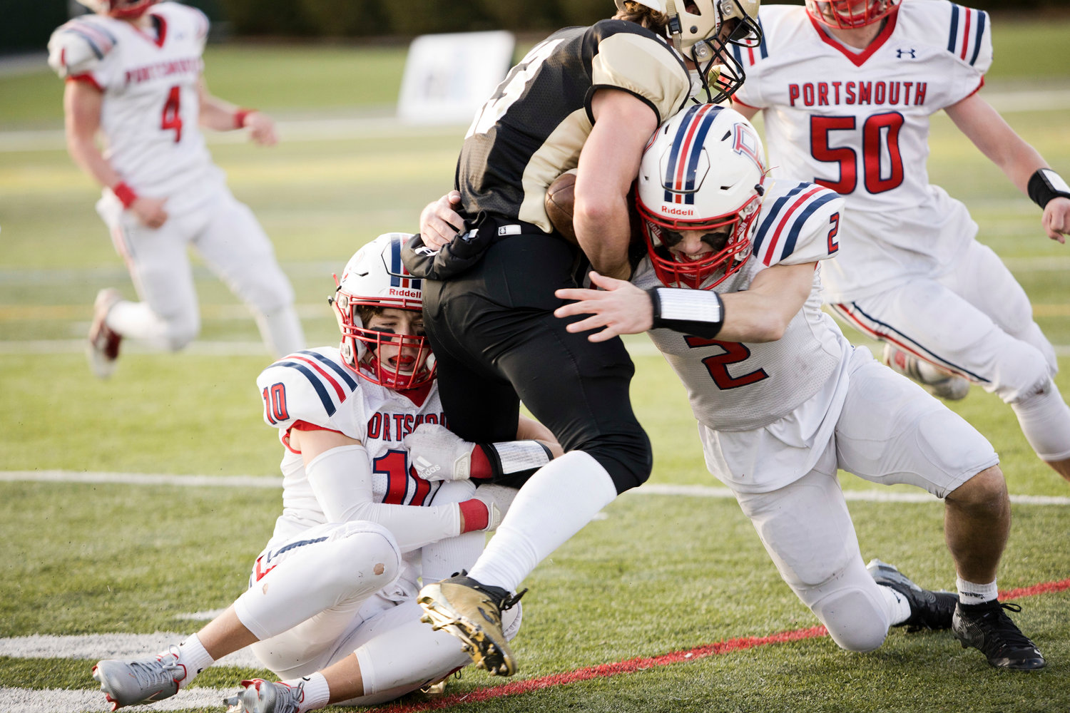 Evan Tullson (left) and Benny Hurd tackle a North Kingstown ball-carrier.