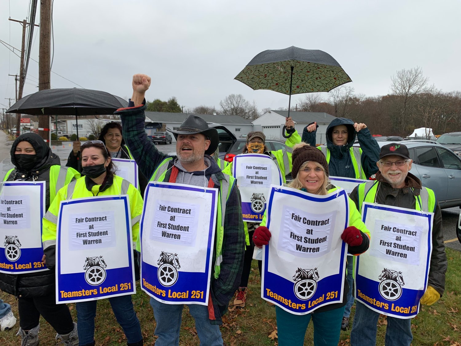 Steven King, joined by fellow members of Teamsters Local 251, raises his fist during an informational picket held outside of the First Student depot in Warren on Monday morning.