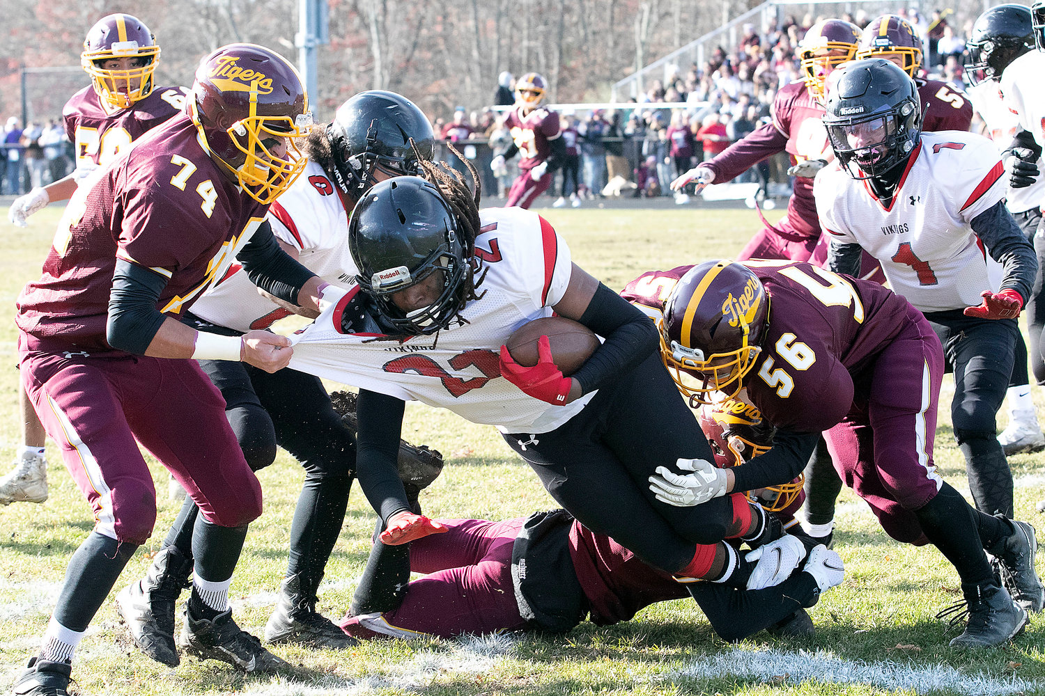 Tigers linebackers Ali Chamseddine (left) and Colby Brown take down a Rogers runningback.