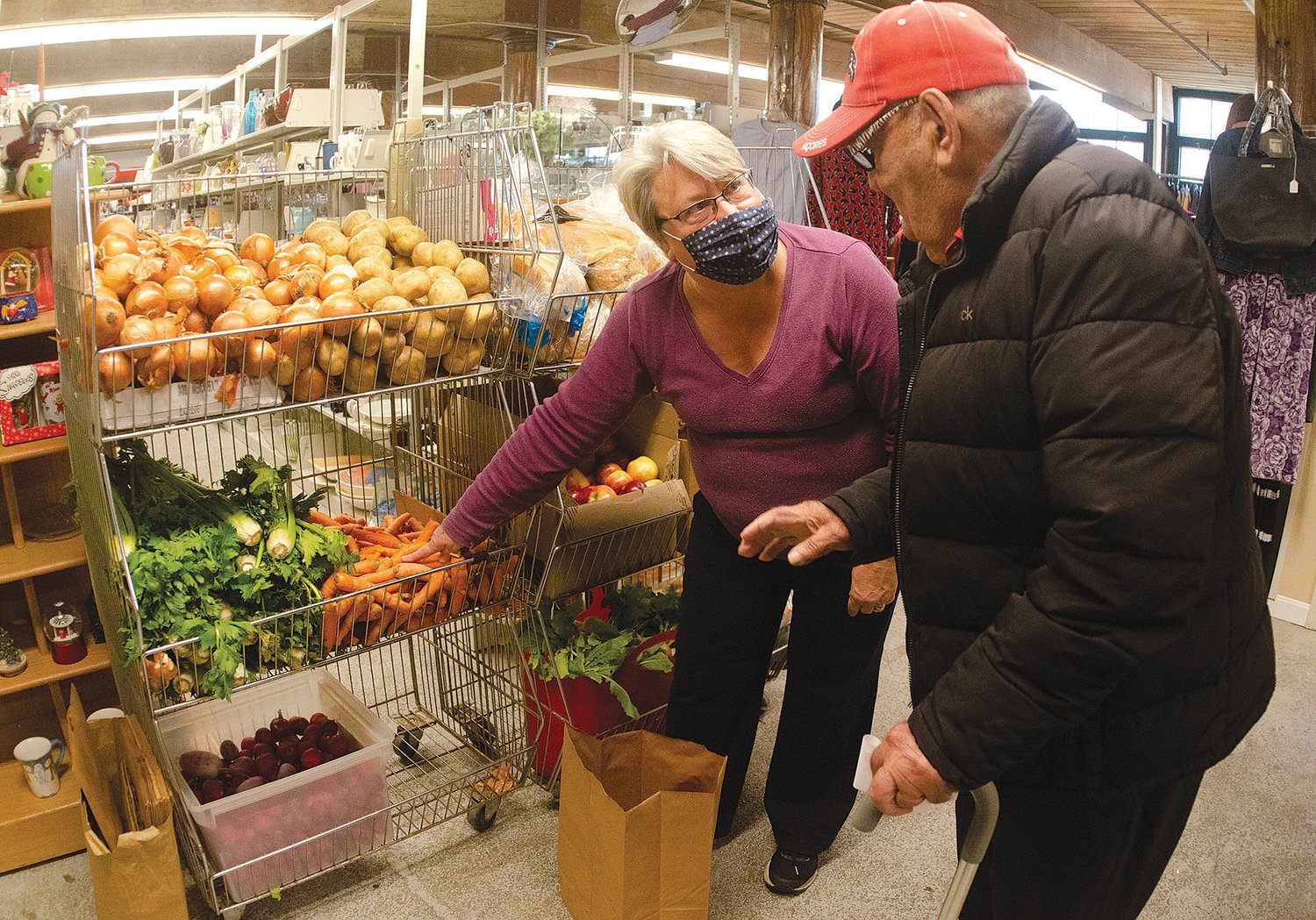Volunteer Elizabeth Peters helps client Joe Barreiro with selecting produce during a visit to the East Bay Food Pantry in Bristol last week.