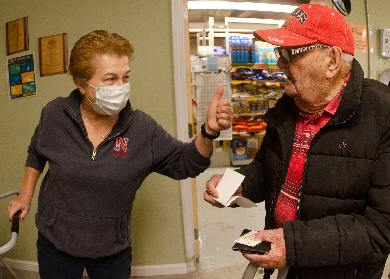 East Bay Food Pantry volunteer Diane Lennon gives client Joe Barreiro a coupon and some words of encouragement. 