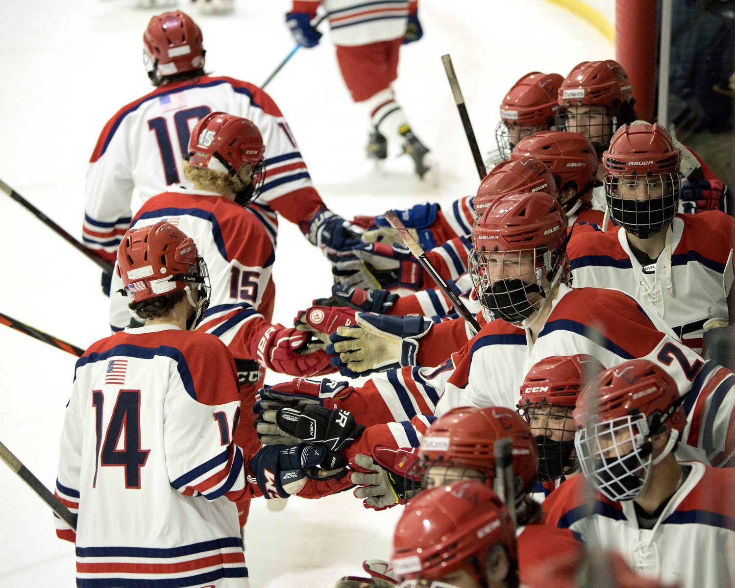 Members of the Portsmouth High boys’ hockey team celebrate their Injury Fund victory over Barrington on Sunday.