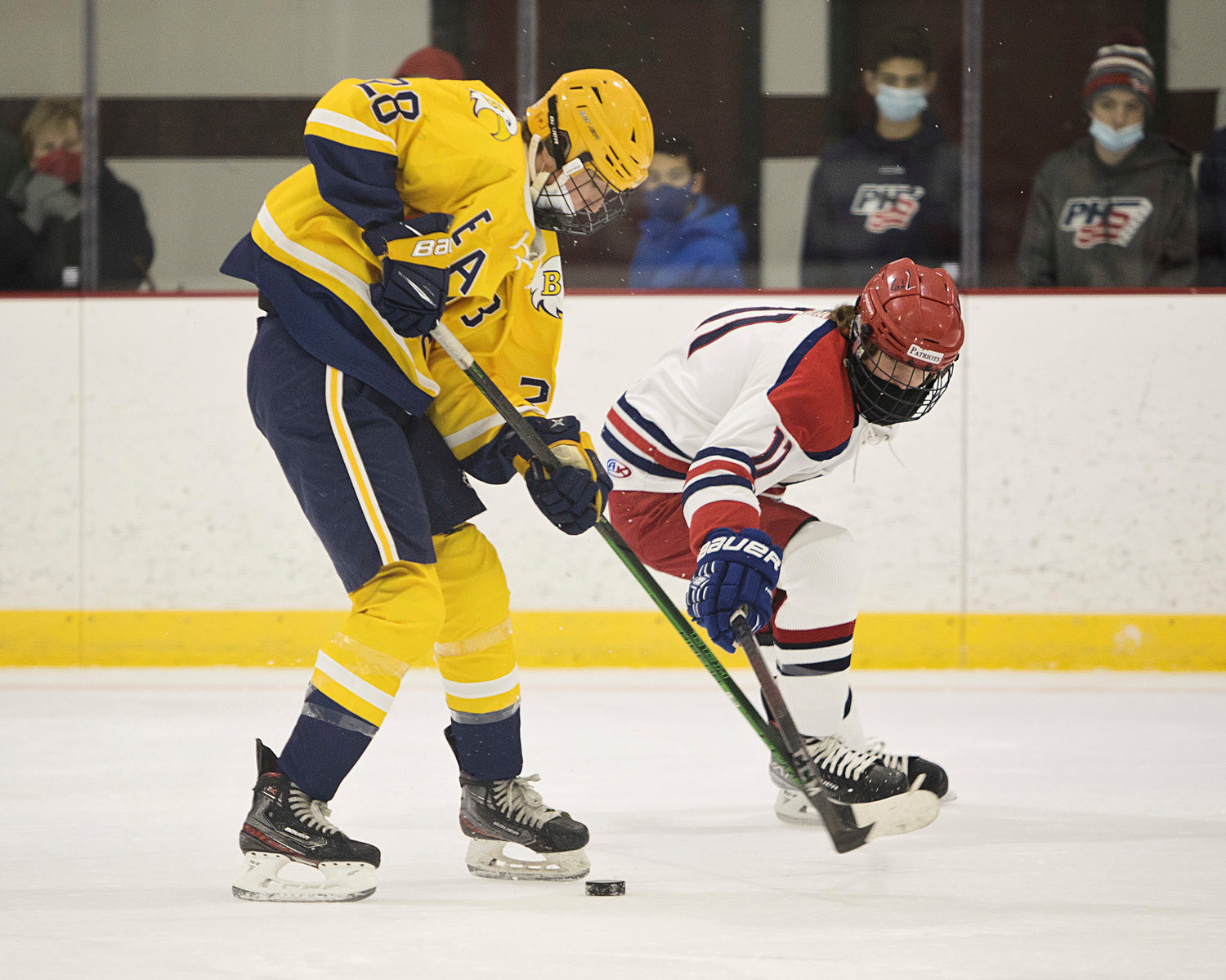 Chase Watts is pressured by a Portsmouth opponent while advancing the puck toward the goal.