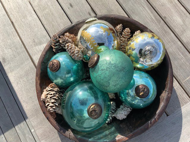 These turquoise balls in a bowl are from Groundswell Garden + Home in Tiverton. Mixed with pine cones from the backyard, they create an elegant setting.