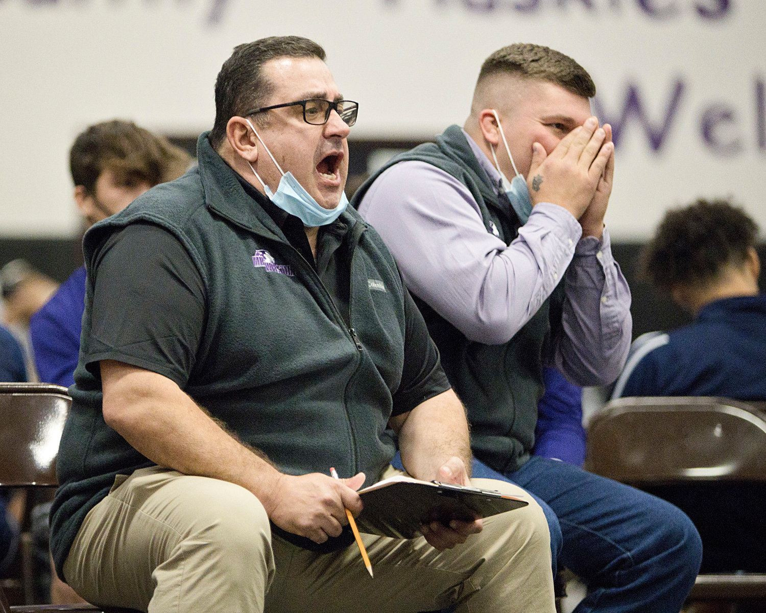 Huskies new head coach Mike Perreira (left) and assistant coach Colt Cotten, give advice to a Huskies wrestler during the Sharon Lombardo tournament at Mt. Hope High School on Saturday.