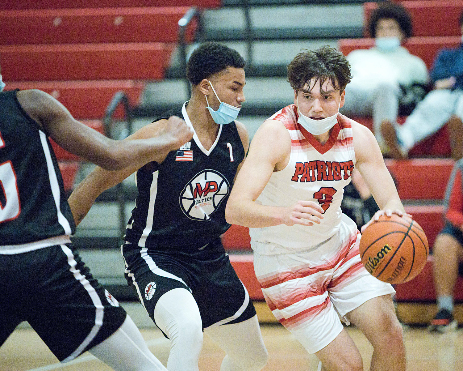Jack Downing is pressured by a Mt. Pleasant opponent while controlling the ball toward the hoop.