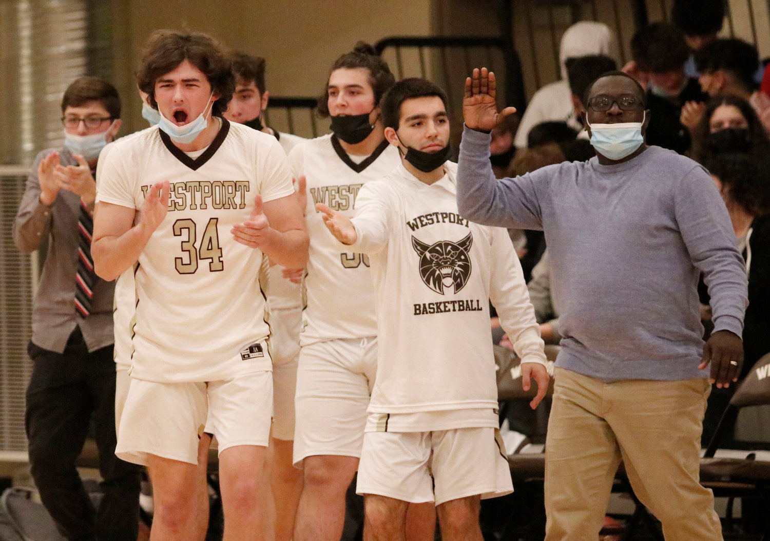 Liam Malloy (left), Nick Arruda and the bench cheer the team as they come in with a big halftime lead.