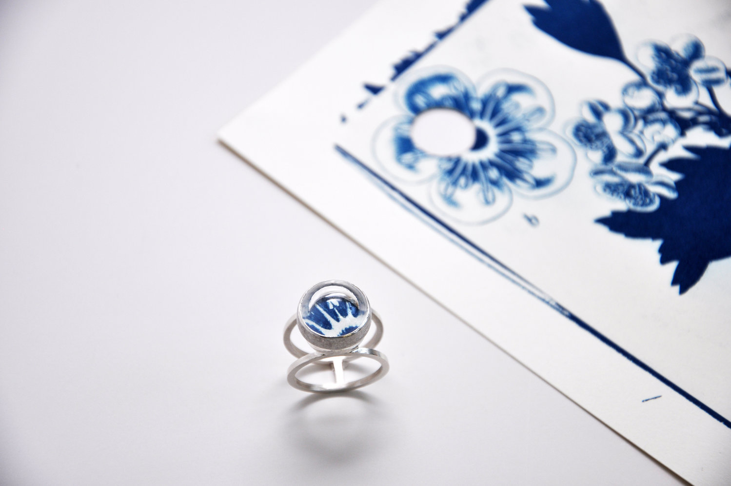 Reiss looked for interesting samples from the cyanotypes that would fit into a space small enough to be set on a ring, which she cut out. Each ring features a quartz rock crystal lens that magnifies the embedded botanical image.